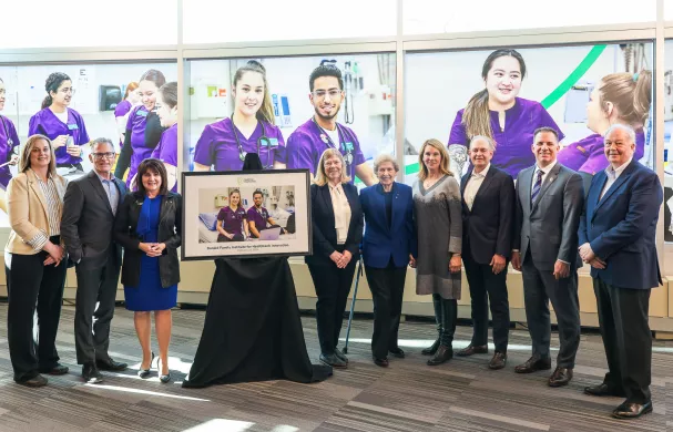 Members of the Donald Family, RDP, and government stand next to a commemorative photo.