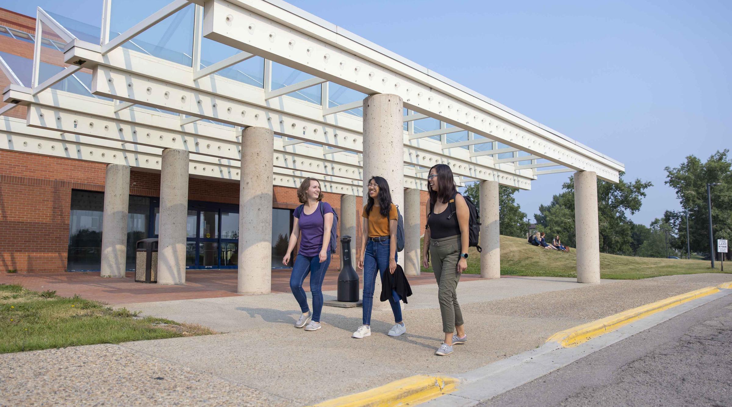 Three students walking outside 