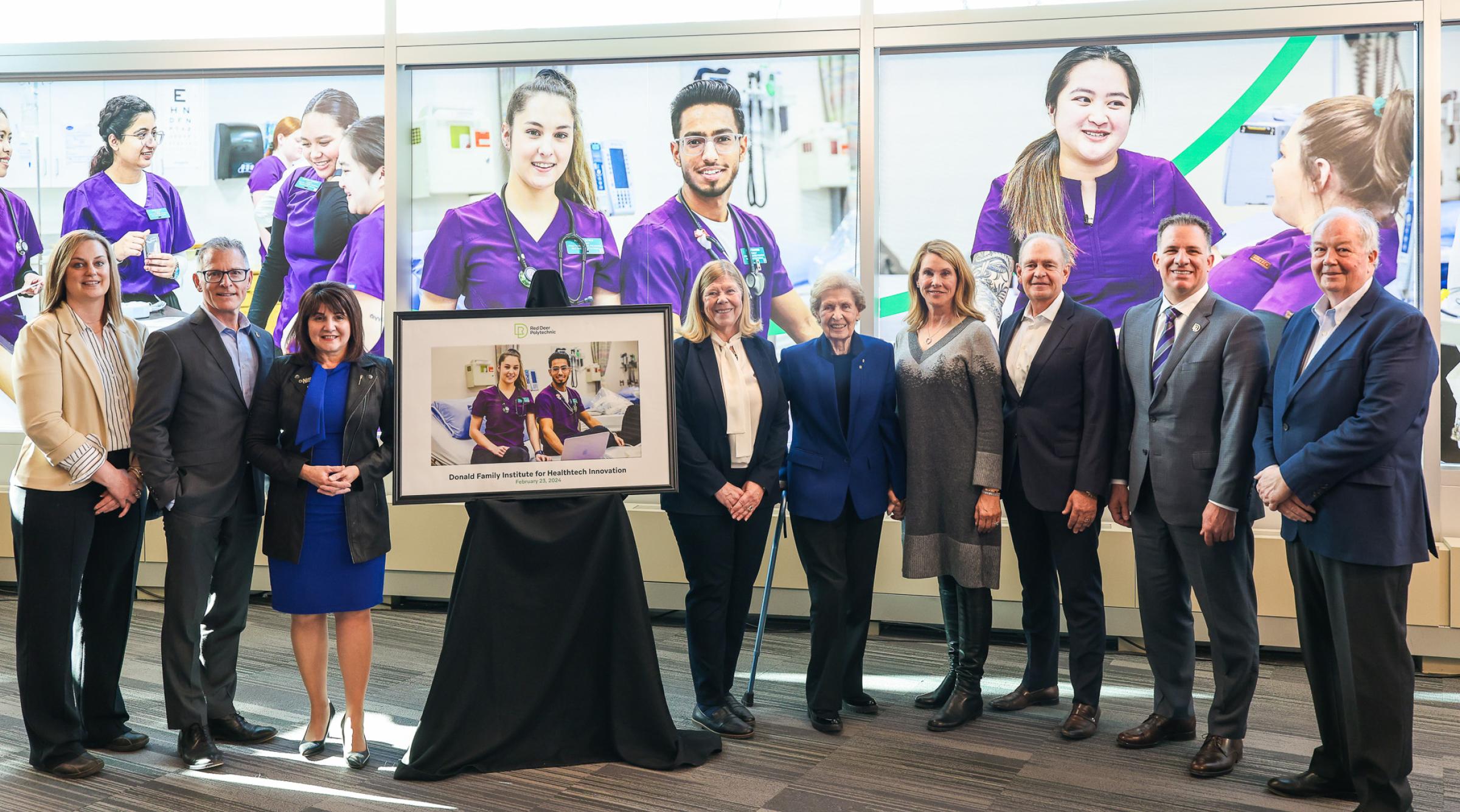 Members of the Donald Family, RDP, and government stand next to a commemorative photo.