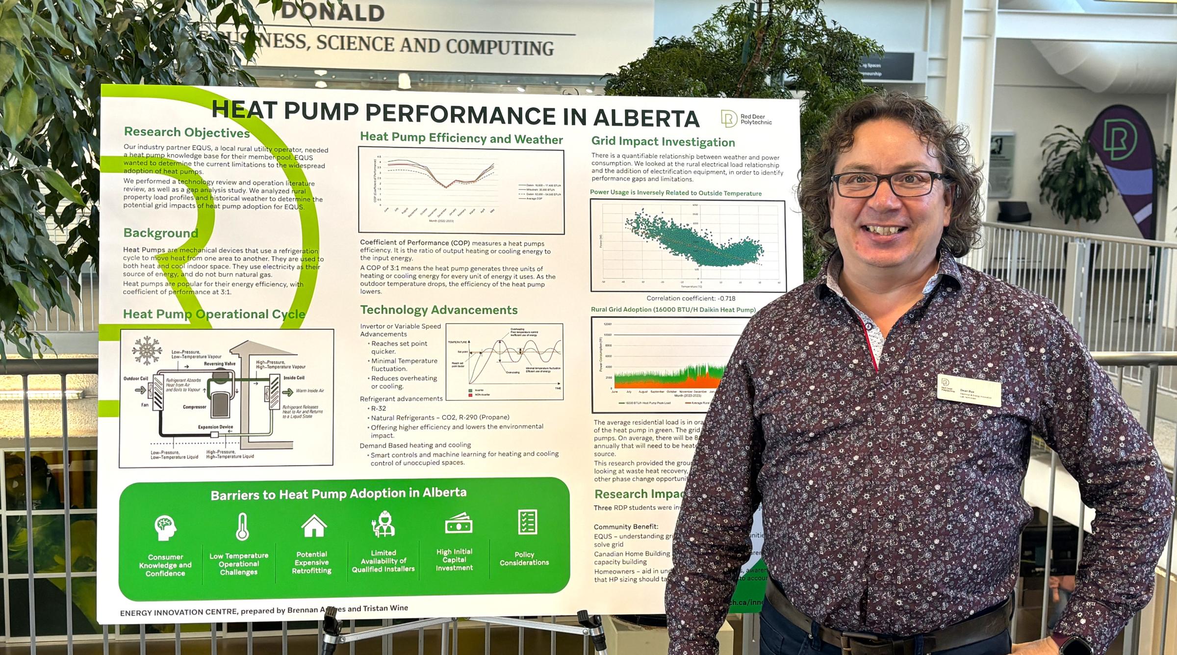 A researcher in a purple shirt stands with a hand on their hip, next to a presentation board that reads "heat pump performance in alberta"