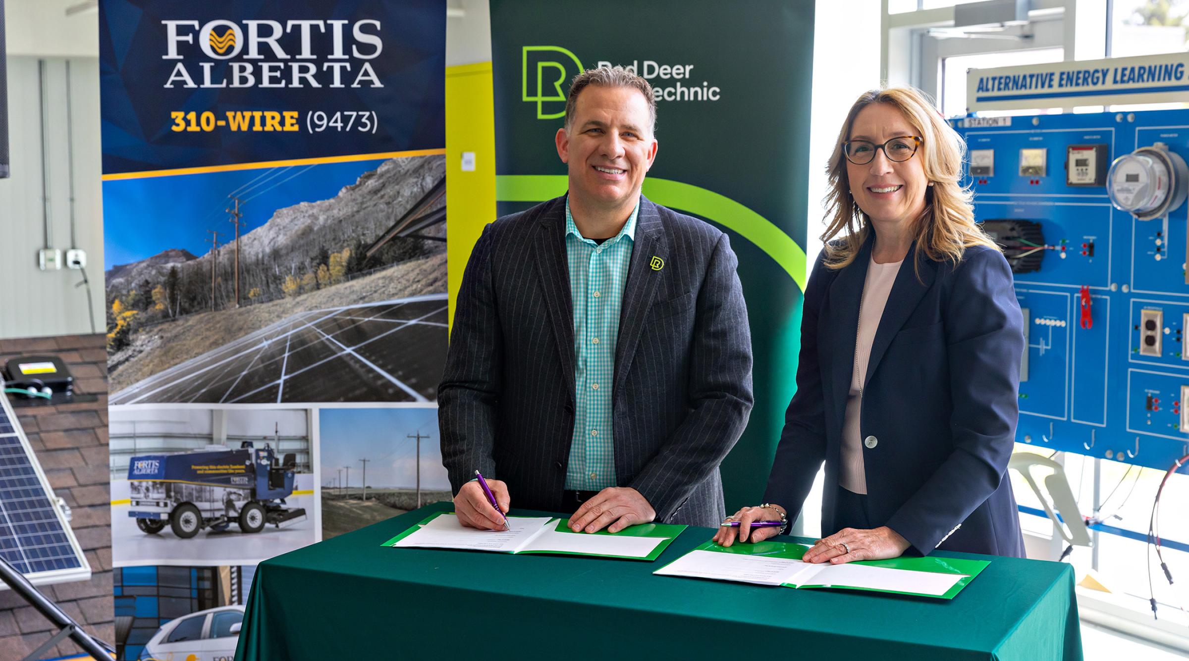 Stuart Callum & Janine Sullivan signing a MOU while smiling at camera