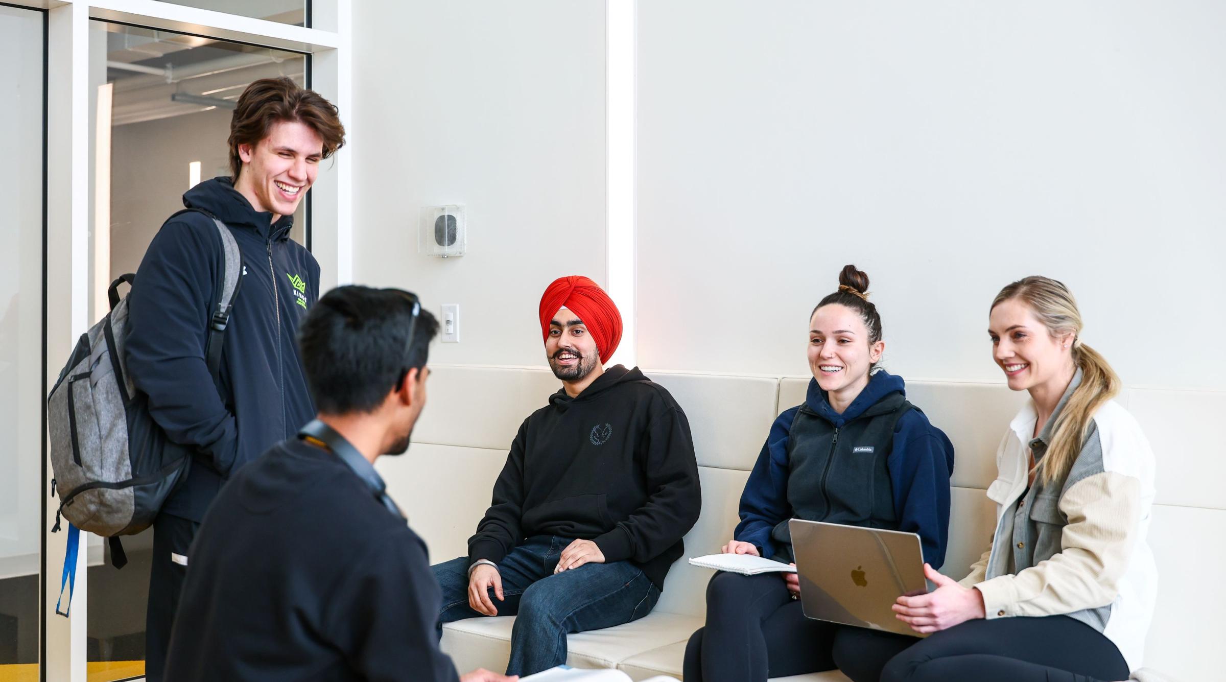 A group of diverse students chat in the new residence building at RDP