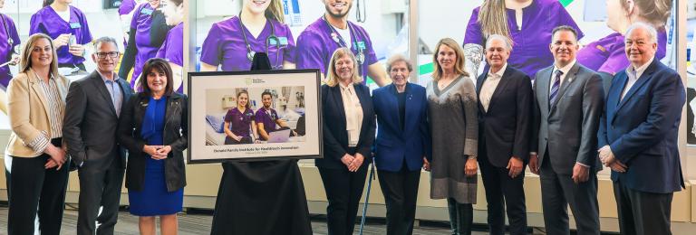 Members of the Donald Family, RDP, and government stand next to a commemorative photo.