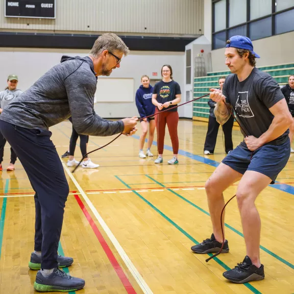 Kines instructor in gym demonstrating exercise to students