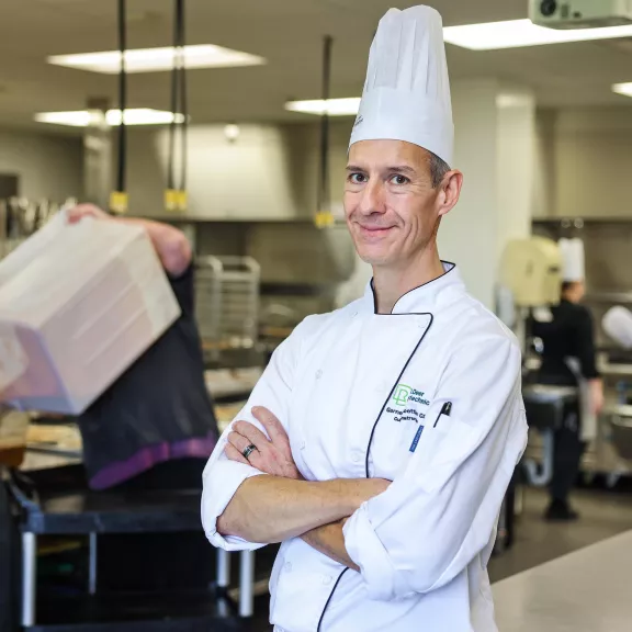 Cook instructor standing in kitchen