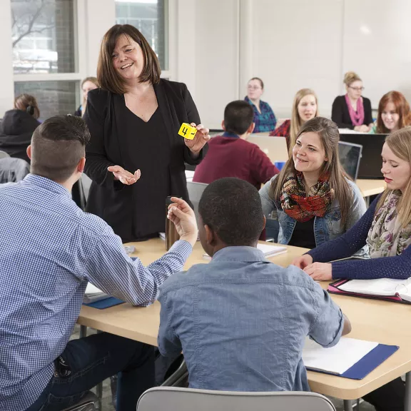 EA instructor talking to students in group project