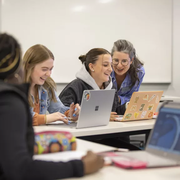 Pre-Health Sciences Instructor helping students on laptop