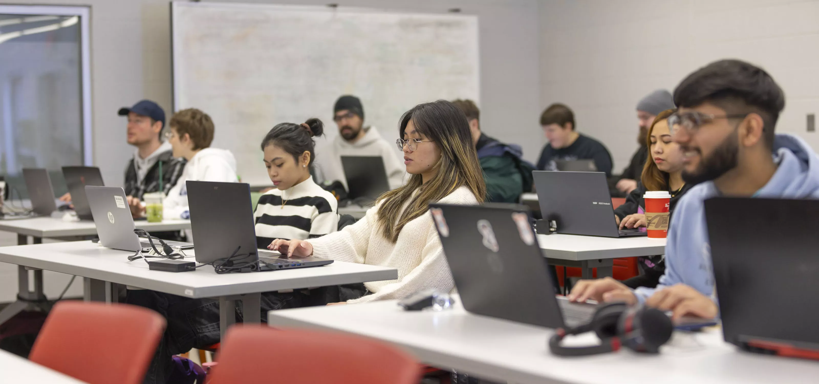 Computer Programming students in classroom on laptops